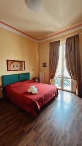 a bedroom with a red bed and a large window at Viareggio live in Top deco in Viareggio