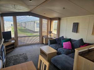 a living room with a couch and a tv at Meadow Lakes 37 in Chapel Saint Leonards