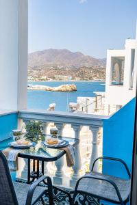 a balcony with a table and chairs and a view of the ocean at Gorgona Traditional 3 in Karpathos Town