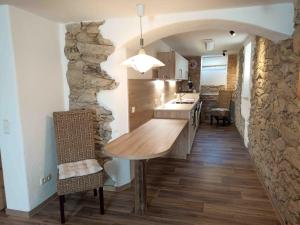 a kitchen with a wooden table and a stone wall at Ferienwohnung Urlaubsbasis Renate in Zittau