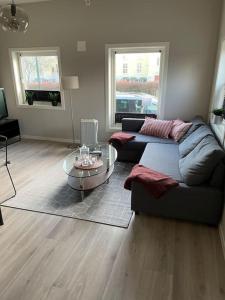 a living room with a couch and a glass table at Practical apartment near city center in Stavanger