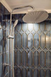 a shower with a tiled wall and a shower head at Gorgona Traditional 3 in Karpathos Town