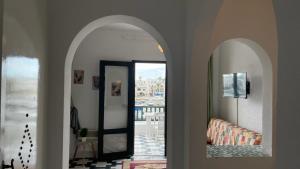 a hallway with two archways with a mirror and a door at Flat Marina Kantaoui in Sousse