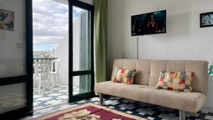 a living room with a couch and a balcony at Flat Marina Kantaoui in Sousse +4 photos