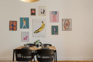 une table à manger avec des chaises et des photos sur le mur dans l'établissement Setubal Terrace apartments, à Setúbal