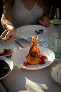 une personne assise à une table avec une assiette de pâtes dans l'établissement Hotel Magdalener Hof, à Bolzano