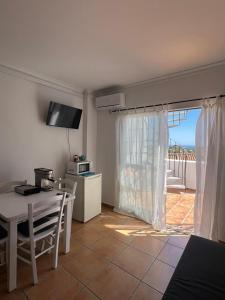 a living room with a table and a kitchen with a balcony at Sultan Costa in Benalmádena