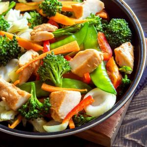 a bowl of food with broccoli and other vegetables at Fly in Viareggio beach in front of the famous promenade with shops and establishments in Viareggio