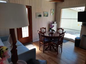 a living room with a table and chairs and a couch at Chalet de Certe in Audenge