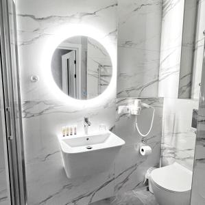 a white bathroom with a sink and a mirror at VEM Apartment Калипсо in Odesa +43 photos