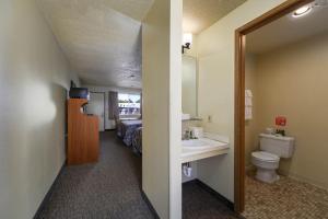 a bathroom with a sink and a toilet and a bed at Cocusa Motel in Burlington +37 photos