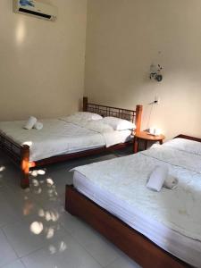 a bedroom with two beds and a table at Ánh Trăng Homestay in Ấp Thiện Phước