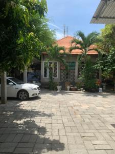 a white car parked in front of a house at Ánh Trăng Homestay in Ấp Thiện Phước