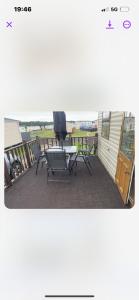 a patio with chairs and a table on a building at Turnberry Holiday Park in Turnberry