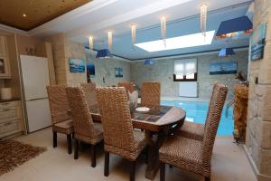 a dining room with a table and chairs and a swimming pool at Villa Sunset Siviri in Siviri