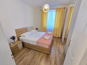 une petite chambre avec un lit et une fenêtre dans l'établissement L etoile Apartment Tirana, à Tirana