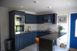 a kitchen with blue cabinets and a sink at The Garden retreat in Killarney