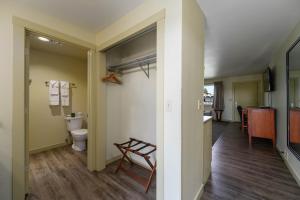 a bathroom with a toilet and a door to a kitchen at Cocusa Motel in Burlington +136 photos
