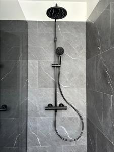 une douche avec pommeau de douche dans une salle de bain dans l'établissement B2 Apartments by Heimaleiga, à Reykjavik