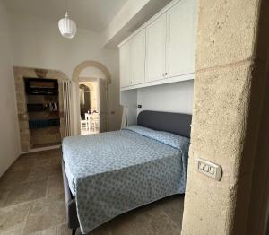 1 dormitorio con 1 cama y armario blanco en Egnazia Short Holidays, en Fasano