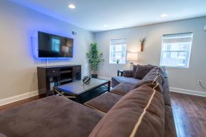 een woonkamer met een bank en een flatscreen-tv bij Stylish 3BR w Pool Table & Garage in Philadelphia