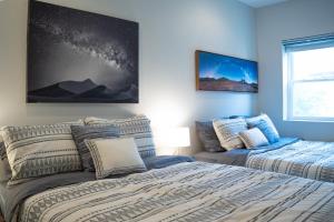 een slaapkamer met twee bedden en een schilderij aan de muur bij Stylish 3BR w Pool Table & Garage in Philadelphia