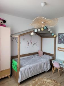a bedroom with a canopy bed with a ceiling at Disney - Résidence Juan Valera in Vaujours