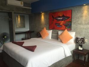 a bedroom with a large white bed with orange pillows at Bro&Sis Place in Koh Tao