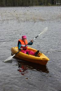 a young girl in a kayak on a lake at Menninkäinen Cottage in Rutalahti