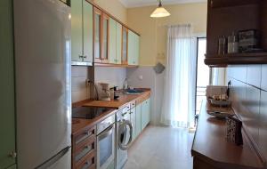 a kitchen with a refrigerator and a washer and dryer at Garitsa Bay Apartment in Corfu