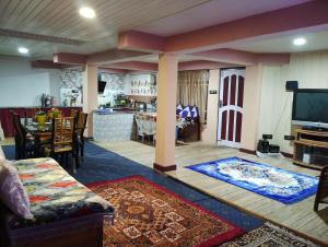 a living room with a television and a dining room at Lepcha Homestay Darjeeling in Darjeeling