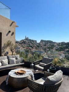 a patio with couches and a table and chairs at Maï Homes - La Villa Bompard in Marseille