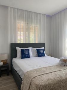une chambre avec un grand lit avec des oreillers bleus et blancs dans l'établissement Luna Nera, à Skala Sotiros