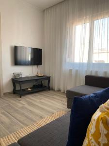 un salon avec une télévision à écran plat et un canapé dans l'établissement Luna Nera, à Skala Sotiros