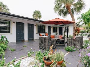 a patio with two chairs and an umbrella at Private Studio Walk to Beach -- Apartment 2 in Pompano Beach