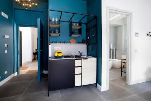 una cucina con pareti blu e piano di lavoro di Estate4home - Design Flat a Piano di Sorrento