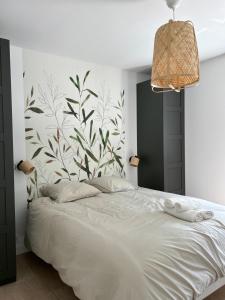 ein Schlafzimmer mit einem weißen Bett mit Blumentapete in der Unterkunft Oïhana Villa & Suites - Piscine chauffée - 4km de la plage in Labenne + 36 Fotos
