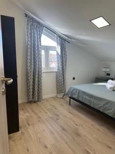 een slaapkamer met een bed en een raam bij Apartment Roni in Zadar