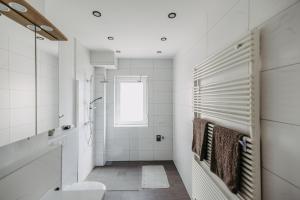 a white bathroom with a toilet and a window at Jordys Ferienapartment in Rechnitz
