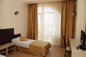 a hotel room with a bed and a window at Assortie Hotel in Derbent