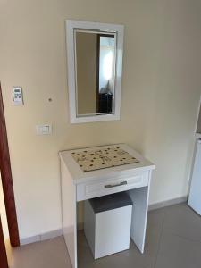 a bathroom with a white table with a mirror at Honey Residence in Sarandë +72 photos
