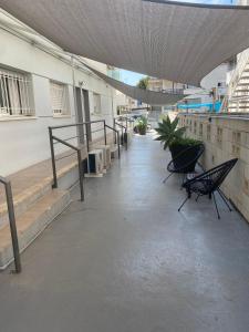 a building with chairs and stairs in a hallway at ROVIOR Rooms & Café in Calafell