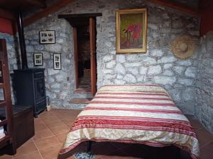 a bedroom with a bed in a stone wall at Casa vacanze San Giorgio in Alcara li Fusi