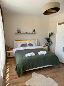 a bedroom with a large bed with two towels on it at Holiday Apartment Town Centre in Kazanlŭk