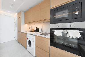 a kitchen with a microwave and a washer and dryer at What a view - very close to DMCC metro station in Dubai
