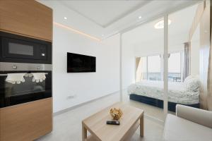 a white living room with a bed and a table at What a view - very close to DMCC metro station in Dubai