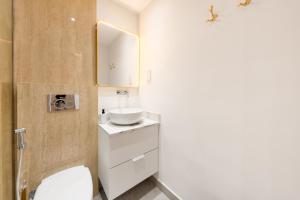 a bathroom with a white toilet and a sink at What a view - very close to DMCC metro station in Dubai
