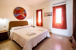 a bedroom with a bed and two windows at Romanos Beach Villas in Romanu