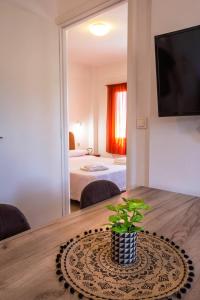 a room with a table with a potted plant on it at Romanos Beach Villas in Romanu