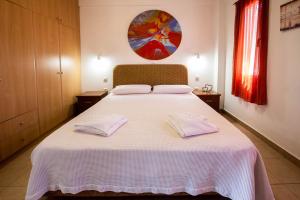 a bedroom with a white bed with two towels on it at Romanos Beach Villas in Romanu